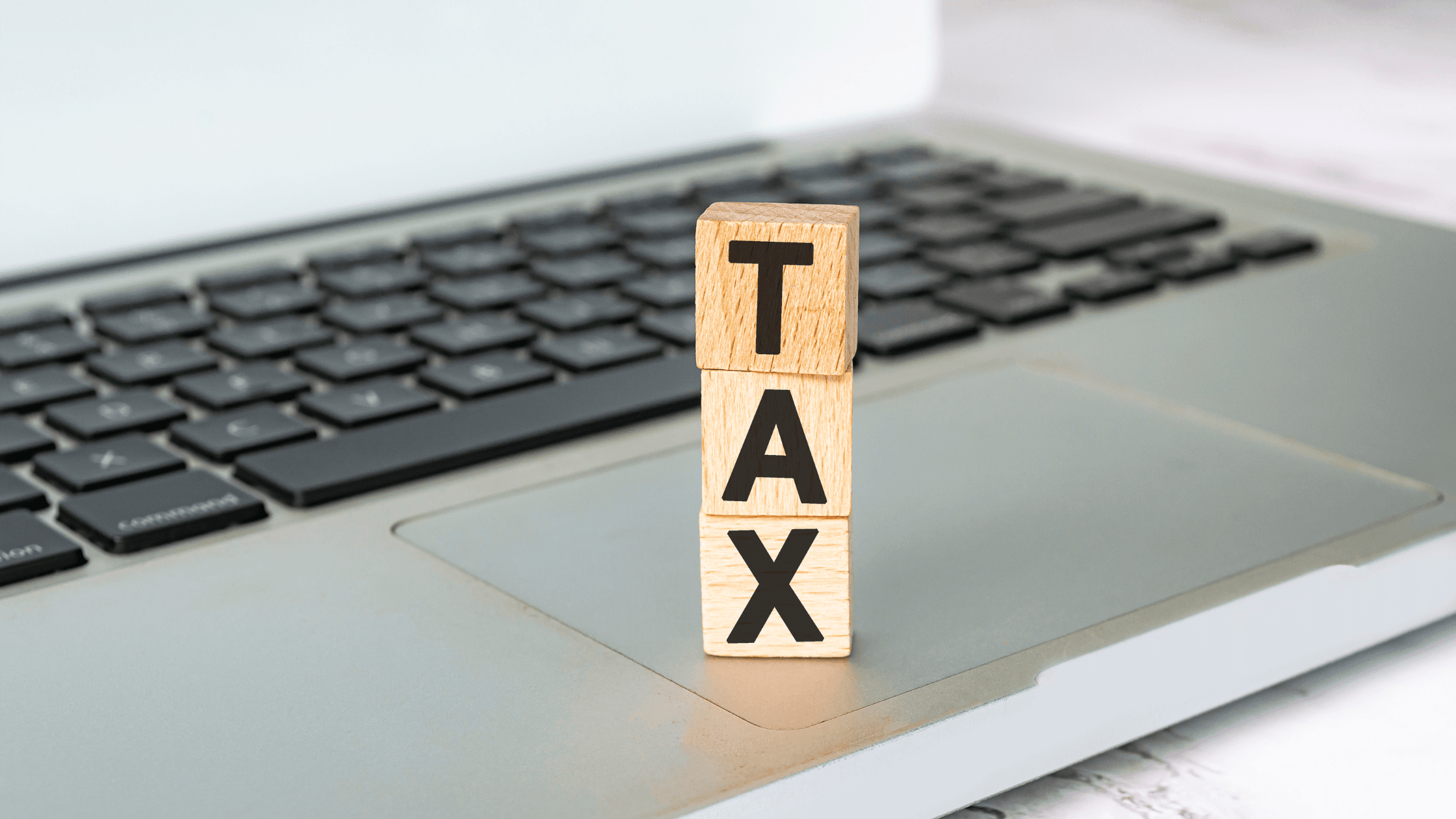 Clavier  de PC avec des cubes en bois sur lesquels sont écrit "TAX"