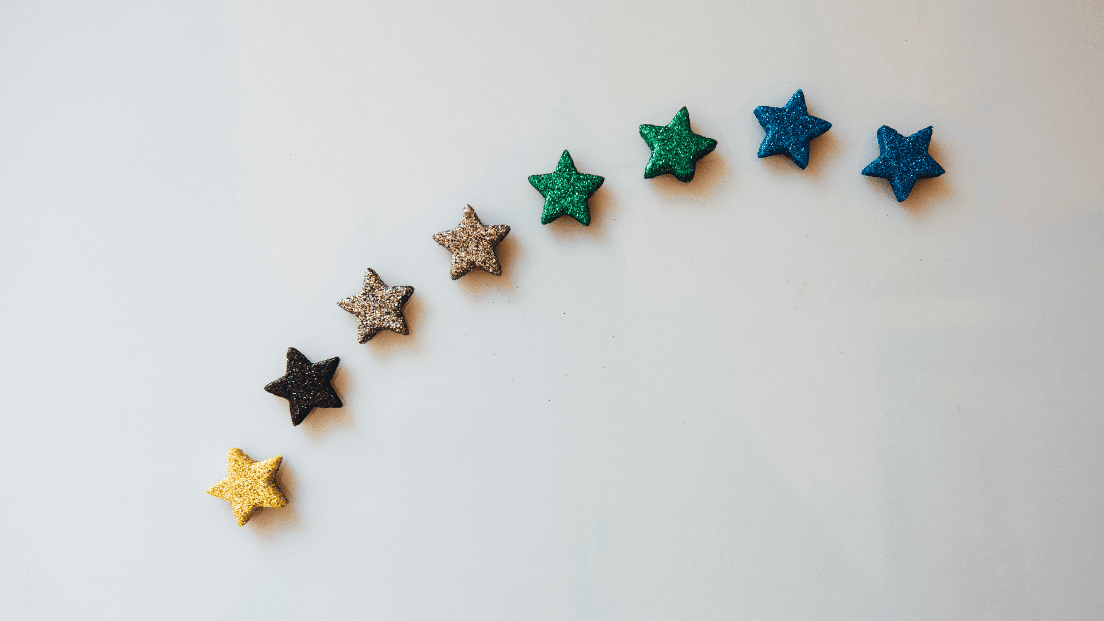 8 petites étoiles en bois colorées sur fond gris