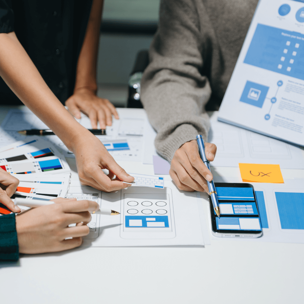 Plusieurs UX Design en train de créer une wireframe sur une table.