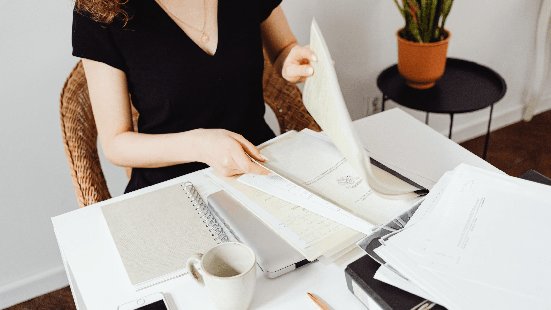 Une femme à son bureau qui tri des papiers