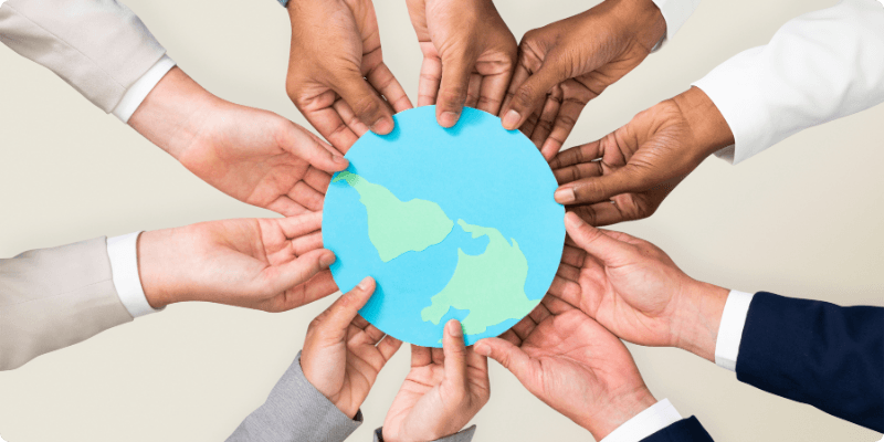 Plusieurs mains qui tiennent une représentation de la Terre